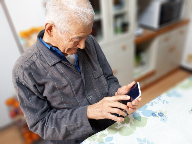 スマホを操作する高齢男性